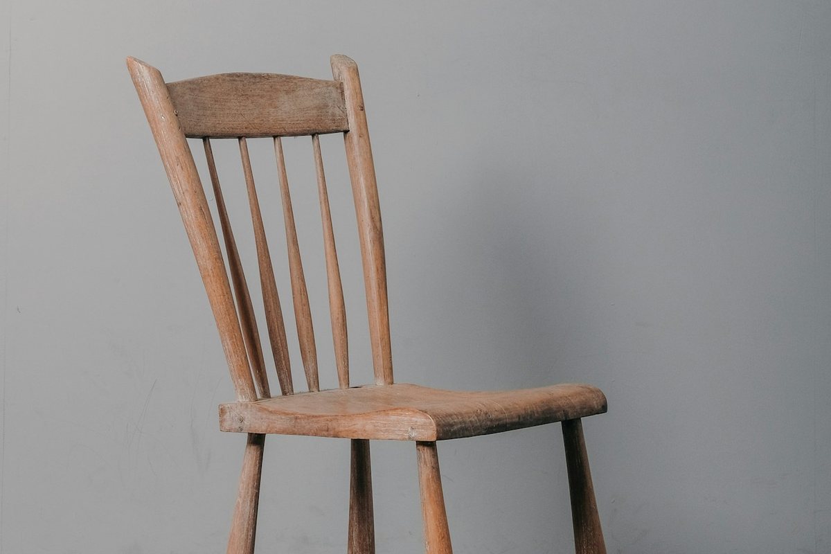 a wooden chair sitting on top of a wooden floor