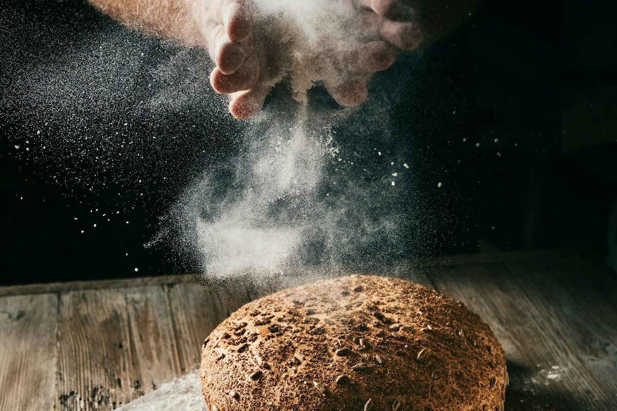 a loaf of bread being sprinkled with flour